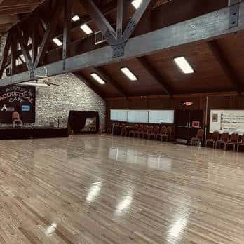 Interior del salón de baile con piso de madera y escenario