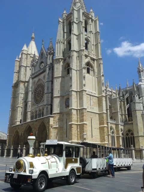 Tren turístico blanco frente a la Catedral de León en un día soleado