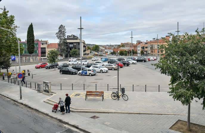 Vista general del aparcamiento de FGC Can Feu-Gràcia con vehículos estacionados y entorno urbano