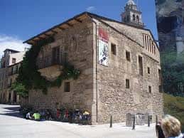 Fachada lateral de la iglesia con detalles arquitectónicos y gente sentada en la plaza