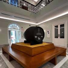 Sala central del museo con gran barrica negra sobre pedestal de madera