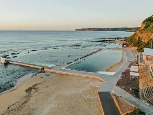 Vista panorámica de los Ocean Baths al atardecer con el mar y la costa