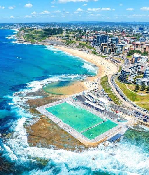 Vista aérea de los Ocean Baths rodeados por la playa y la ciudad de Newcastle