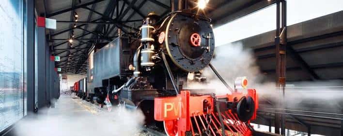 Locomotora de vapor emitiendo vapor en el hall principal del museo