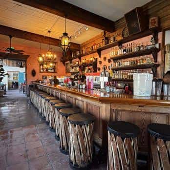 Interior del bar de madera con estanterías llenas de botellas