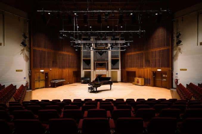 Escenario principal del concert hall con piano de cola y órgano en el fondo