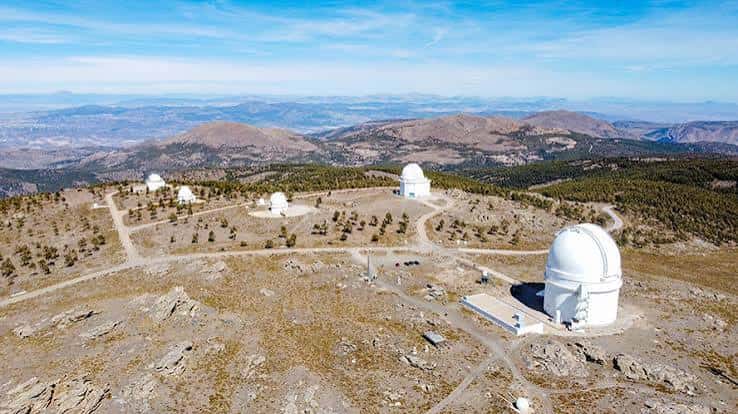 Panorámica aérea de los domos del observatorio en la cima montañosa