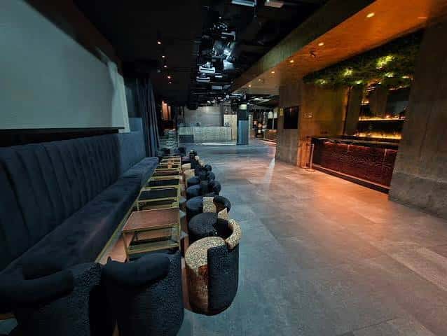 Interior moderno del club con sofás y barra de bar