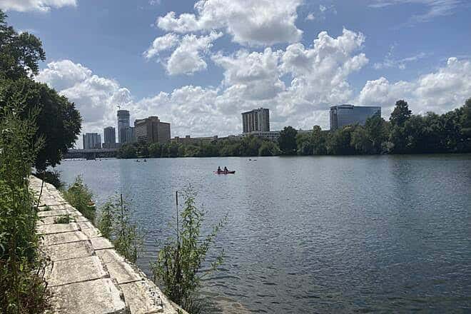 Vista panorámica del río Shoal Creek con kayakistas y el skyline de Austin al fondo