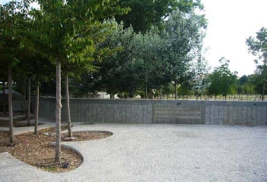 Área abierta de la explanada con arboles y muro de fondo