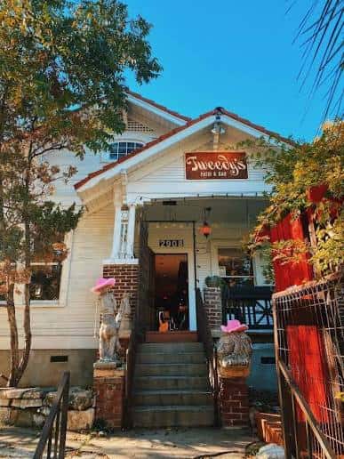 Fachada exterior de Tweedy's Bar con letrero y escaleras