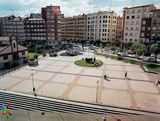 Vista panorámica del parque con plaza central y edificios de fondo