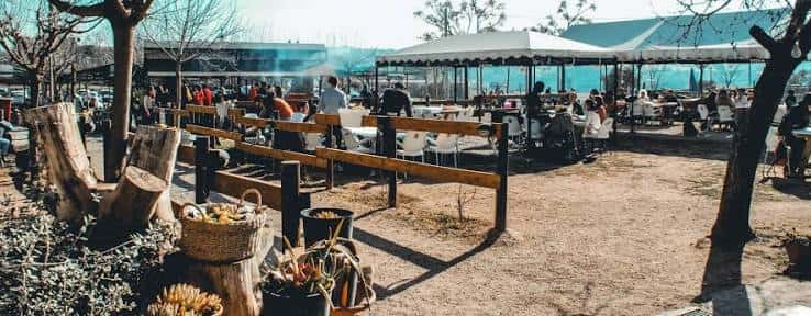 Terraza exterior de Mas Portell con mesas bajo carpas y ambiente festivo