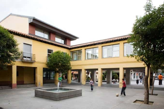 Plaza frontal del Ayuntamiento con fuente, arcos y personas disfrutando del espacio público