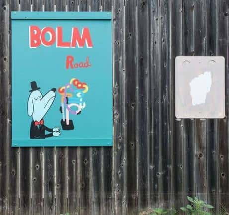 Señal de Bolm Road con arte callejero y un personaje ilustrado