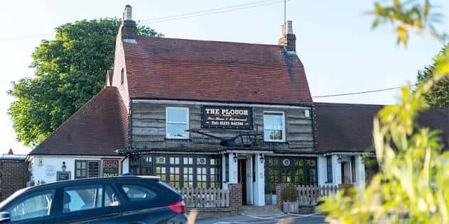 Vista exterior del pub The Plough Pyecombe con su fachada tradicional de madera y techo de tejas
