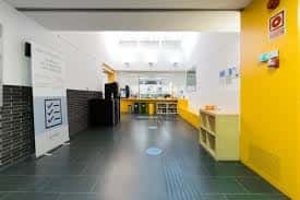 Área interior con paredes amarillas y mobiliario infantil, ideal para eventos familiares