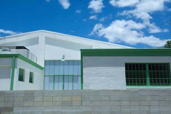 Fachada exterior del edificio blanco con detalles en verde