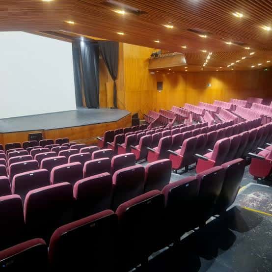 Vista general del interior del auditorio con butacas rojas y escenario