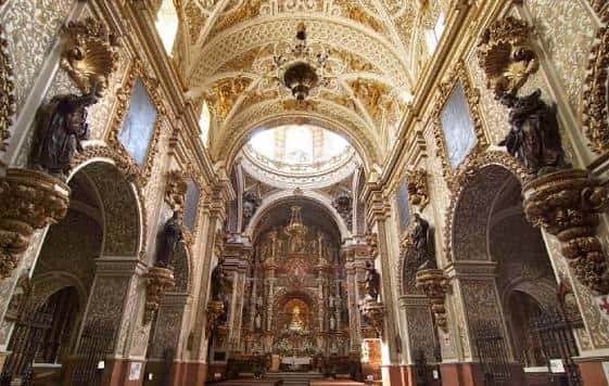 Vista interior de la nave principal con bóveda decorada y altar mayor al fondo