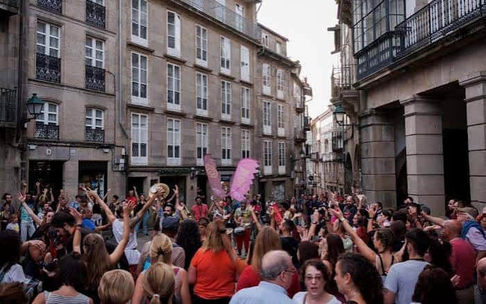 Multitudinaria multitud celebrando en una calle histórica de Santiago de Compostela durante el Festival Maré