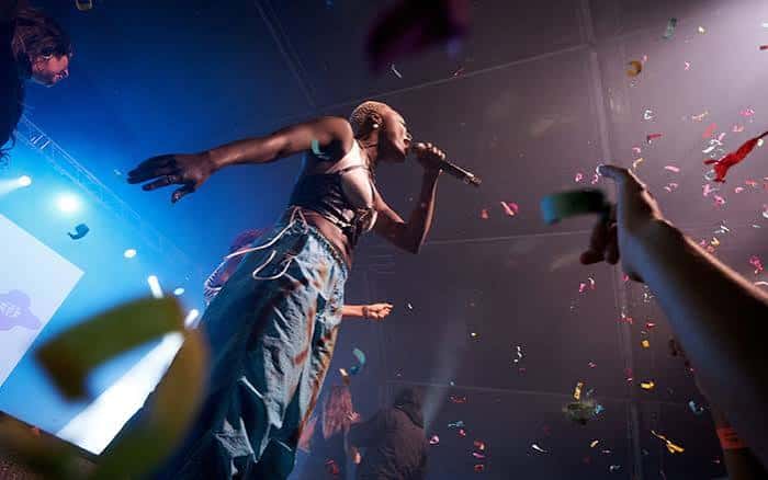 Artista actuando en vivo con confeti cayendo sobre el público en un concierto del Festival Maré