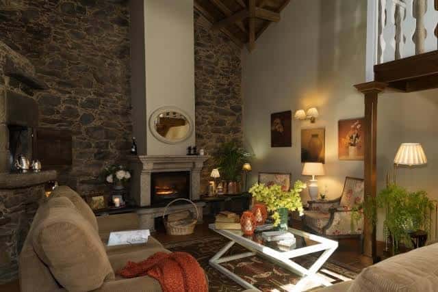 Salón acogedor con chimenea de piedra y decoración tradicional gallega