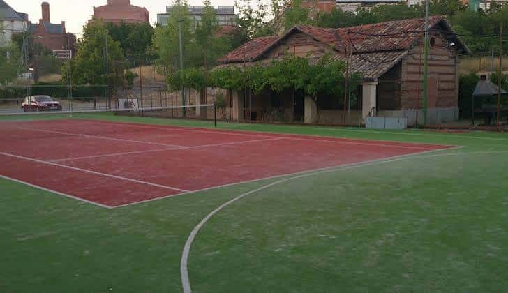Pista de tenis al aire libre con suelo rojo y verde en el Centro Deportivo Cultural Delicias