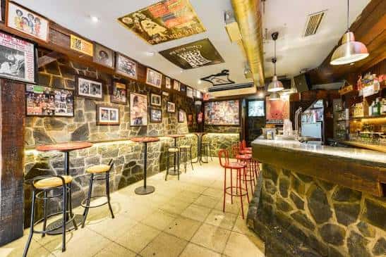 Interior del bar El Refugio con paredes de piedra y decoración temática