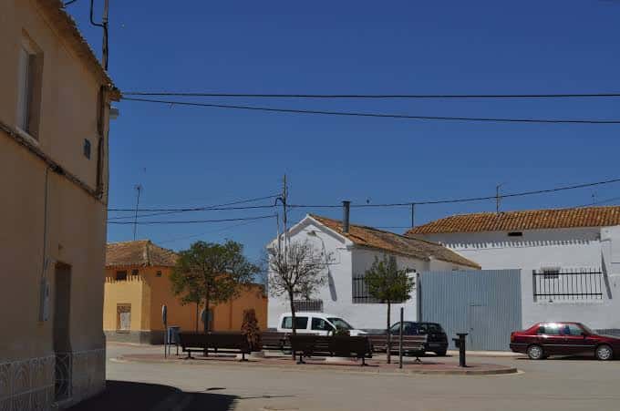 Plaza principal del pueblo con edificios tradicionales y bancos