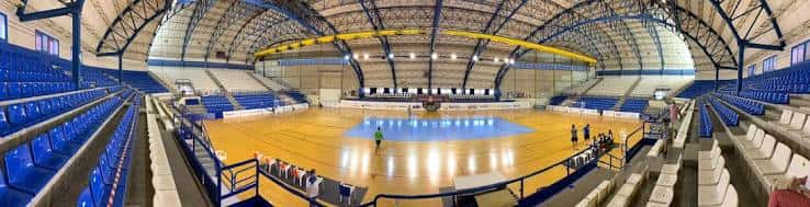 Vista panorámica del interior del Palau d'Esports con gradas azules y cancha de madera