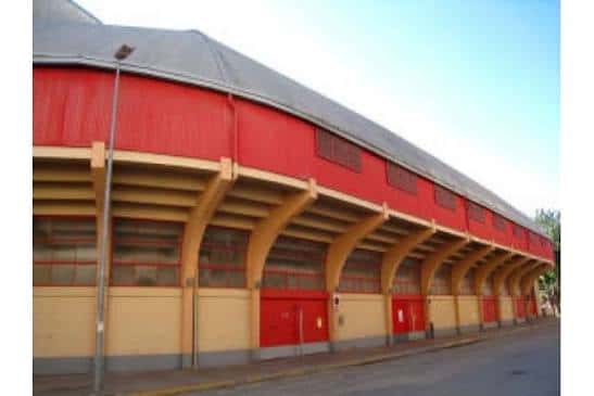 Fachada exterior del edificio con estructura roja y arcos amarillos