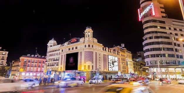 Vista nocturna del Cine Callao iluminado en la Plaza del Callao