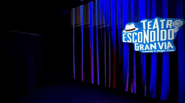 Escenario con cortinas azules y logotipo del Teatro Escondido Gran Vía