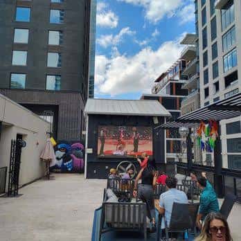 Terraza exterior de Clive con pantalla de cine al aire libre y clientes disfrutando
