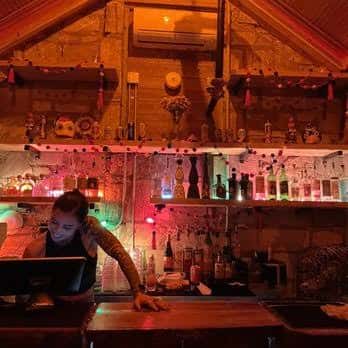 Interior del bar Clive con barra iluminada y ambiente acogedor