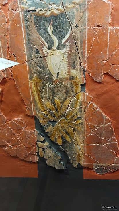 Detalle de un fresco romano con cisne y motivos florales en pared roja