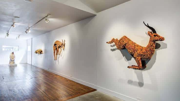 Exposición de esculturas animales en la pared de la galería