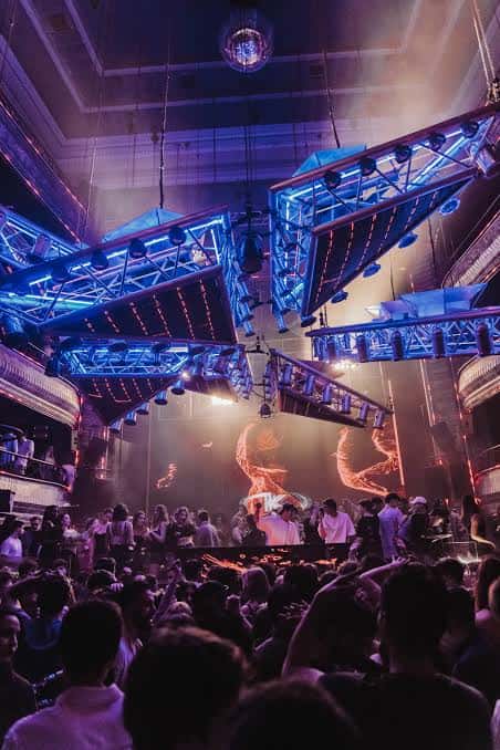Escenario iluminado con luces de neón y estructura metálica en el interior del teatro