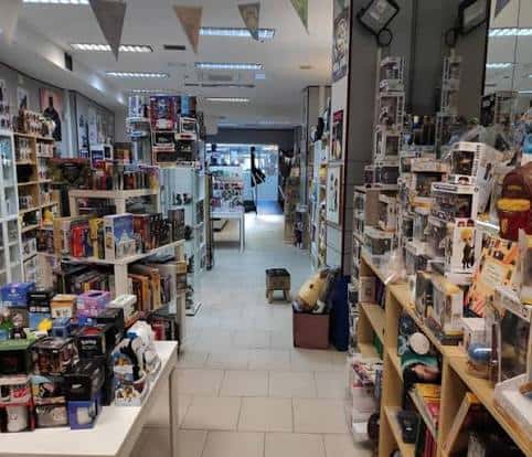 Interior de la tienda mostrando pasillos con estanterías llenas de cómics y coleccionables