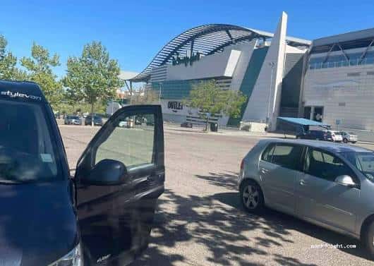 Explanada frente al pabellón multiusos con vehículos estacionados