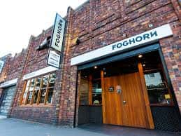 Fachada exterior de Foghorn Brewery con su distintivo letrero y entrada de madera