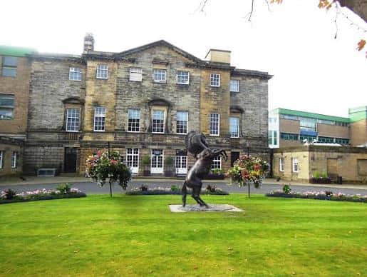 Vista exterior del edificio principal de Newcastle Racecourse con estatua ecuestre en el jardín