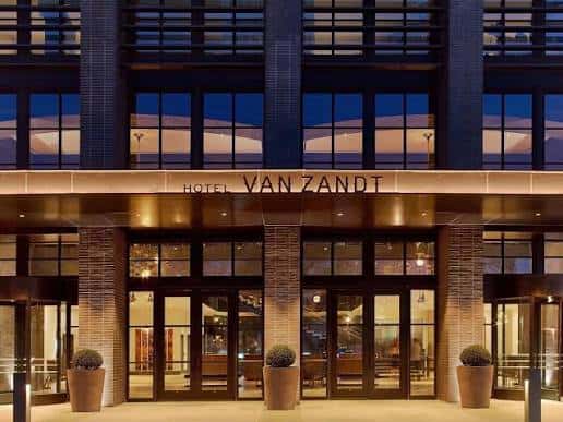 Fachada principal iluminada del Hotel Van Zandt por la noche