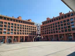Vista panorámica de la Plaza Felisa Munárriz con edificios residenciales de ladrillo rojo y cielo despejado