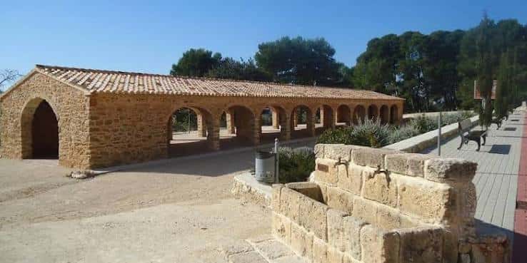 Vista exterior del antiguo Riurau de Benissadeví con arcos de piedra y tejado a dos aguas