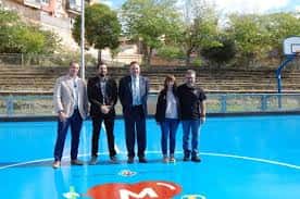 Grupo de personas posando en la pista poliesportiva exterior renovada