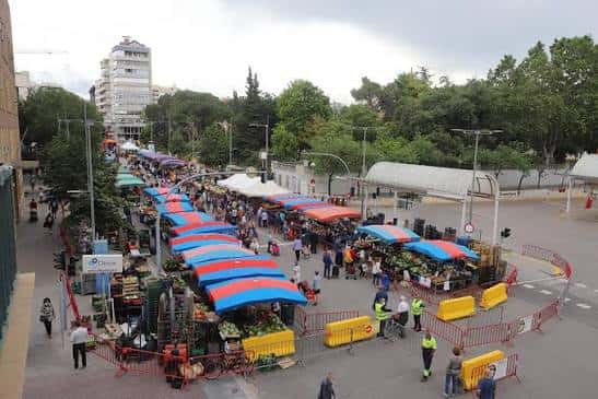 Vista aérea del mercado semanal en Avinguda del Parc con puestos de colores y público