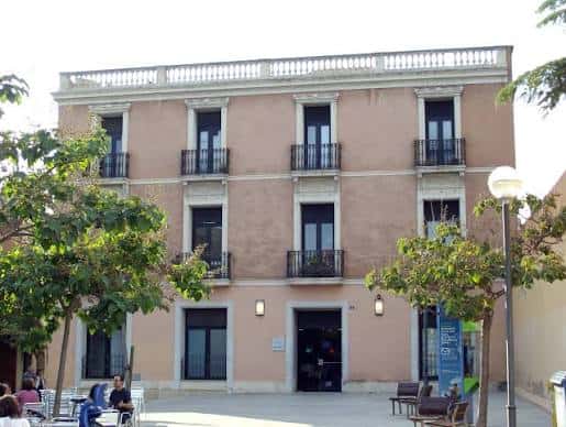 Fachada principal del edificio de la Plaça del Gas con balcones y entrada