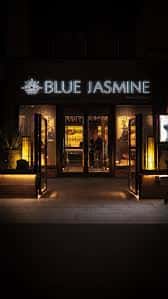Fachada exterior iluminada del restaurante Blue Jasmine por la noche